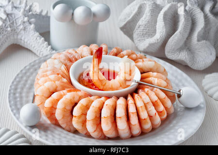 Close-up su anello di gamberi con peperoncino dolce sause su sfondo bianco con decorazioni di mare Foto Stock