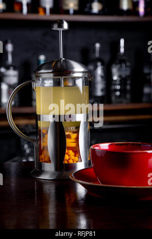 Bacche di olivello spinoso tè nella stampa francese su un sfondo della barra presso la caffetteria. Foto Stock