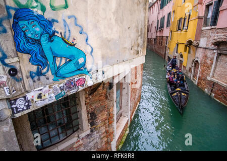 Una gondola, la veneziana tradizionale barca a remi, è una crociera su un piccolo canale tra difficoltà case in mattoni della cosiddetta "città galleggiante' Foto Stock