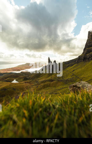 Il vecchio uomo di Storr con erba in primo piano e il sole lo scoppio attraverso la drammatica nuvole durante l'autunno (Isola di Skye in Scozia, Regno Unito) Foto Stock