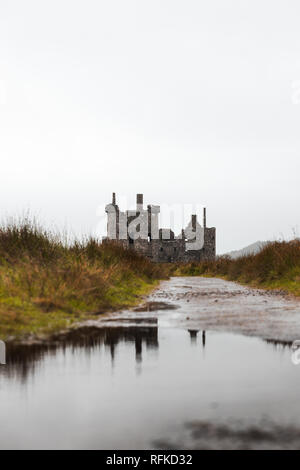 Riflessioni delle rovine di Kilchurn Castle vicino a Loch Lomond durante una piovosa giornata d'autunno con il percorso al castello (Scozia, Regno Unito, Europa) Foto Stock