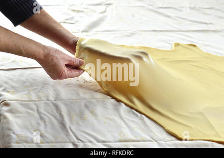 Stretching la pasta per lo strudel su un tavolo da cucina Foto Stock