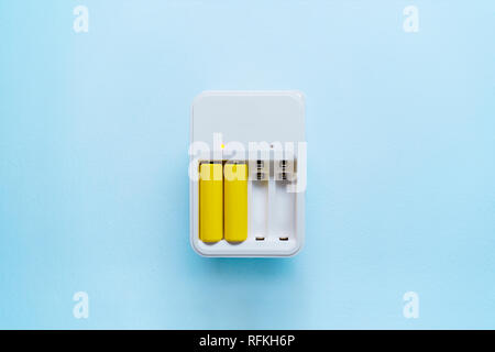 Immagine di un caricabatterie con batterie di colore giallo Foto Stock