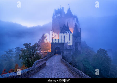 Il gotico medievale Burg Eltz castello nella nebbia mattutina, Germania. Eltz castello è uno dei più imponenti e famosi castelli in Germania. Foto Stock