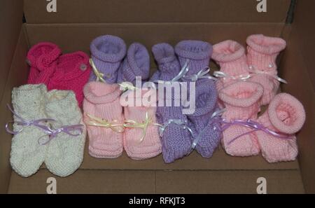 Ragazza di maglia Baby Stivaletti con nastri allineati in fila - colori: rosa, viola, bianco Foto Stock