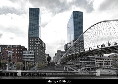 Vista sulle due torri Torres de Urbitrate e il ponte pedonale oltre il fiume Nervion di Bilbao, Spagna Foto Stock