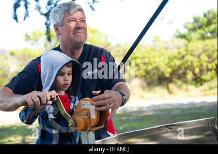 Padre e figlio verricello operativo su un camper rimorchio. Foto Stock