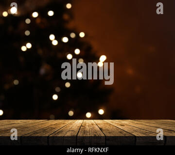 3D render di un tavolo di legno che guarda a un defocussed albero di Natale Foto Stock