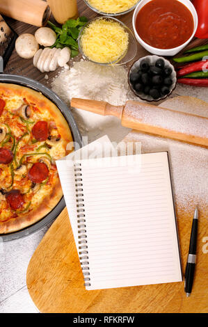 Pane appena sfornato salsiccia per pizza Pizza con vuoto o notebook cookbook, taglieri e vari ingredienti Foto Stock