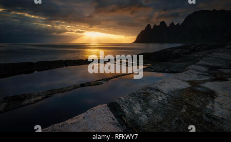 Tugeneset costa rocciosa con le montagne sullo sfondo al tramonto Foto Stock