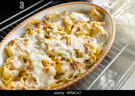 Crepes al forno, arrotolato con funghi porcini, prosciutto, besciamella, formaggio Foto Stock