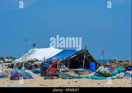 Pescatori tende di fortuna e reti sulla spiaggia di Marina sulla baia del Bengala vicino a Chennai, India Foto Stock