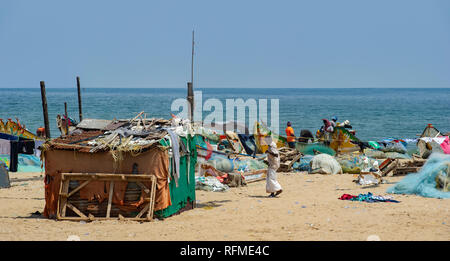 Pescatori tende di fortuna e reti sulla spiaggia di Marina sulla baia del Bengala vicino a Chennai, India Foto Stock