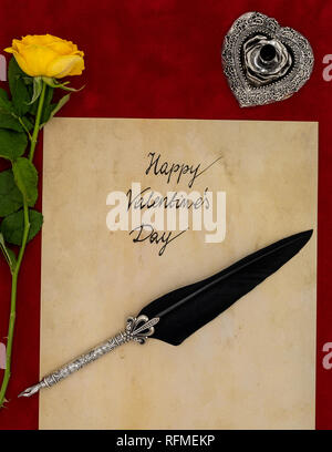 Classic Buon San Valentino card scritto a mano su pergamena vintage rosa gialla argento e del cappello del supporto su Borgogna tessuto in velluto vista superiore Foto Stock