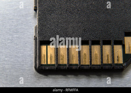 Chiudere la scheda di memoria SD card per le moderne fotocamere digitali sul metallo grigio sfondo Foto Stock