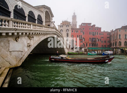 Il Ponte di Rialto e il Ponte di Rialto, un arco in pietra bridge, che attraversano il Canal Grande, Canal Grande su una mattinata nebbiosa Foto Stock