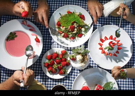 La famiglia a tavola a mangiare fragole dolci vista superiore Foto Stock