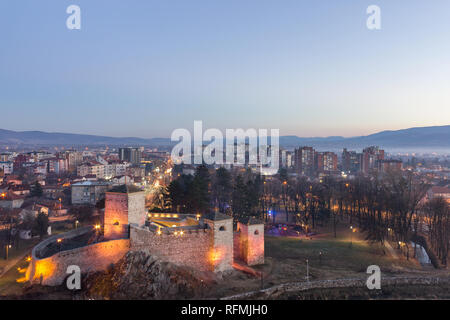 Ora blu vista di Pirot cityscape, luci della città e antica fortezza Foto Stock