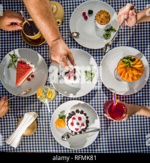 La famiglia a tavola a mangiare fragole dolci vista superiore Foto Stock