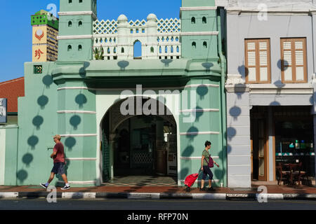 Persone di passaggio Moschea Jamae in Chinatown, Singapore, le ombre delle lanterne cinesi appesa sopra la strada si vede sulla parete della moschea Foto Stock