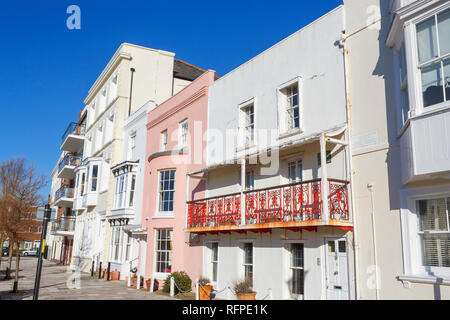 Case in stile georgiano in Grand Parade, Old Portsmouth, Hampshire, Regno Unito tra cui villette a schiera con fiocco rosa una facciata di vetro e rosso di ferro battuto balcone Foto Stock