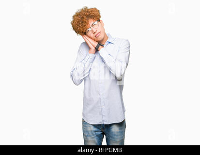 Bel giovane uomo d affari con Afro indossa occhiali sleeping stanchi di sognare e in posa con le mani insieme mentre sorridente con gli occhi chiusi. Foto Stock
