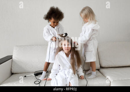 Cura dei capelli nei bambini. Baby acconciature. Ragazze 5-7 anni rendono ogni altri capelli sulle loro teste. Foto Stock