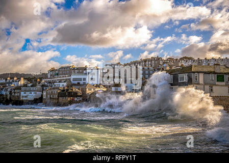 Il mare in tempesta che si schiantano contro la parete del porto e che si infrangono sulle case di St.ives Cornwall Regno Unito Europa Foto Stock