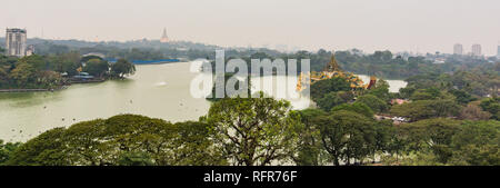 Vista del lago Kandawgyi in una piovosa serata con golden Shwedagon pagoda a distanza Foto Stock