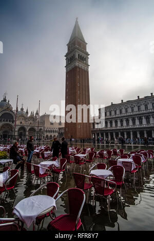 Piazza San Marco, Piazza San Marco, vuote con tavoli e sedie di un ristorante, inondati durante l'acqua alta Foto Stock