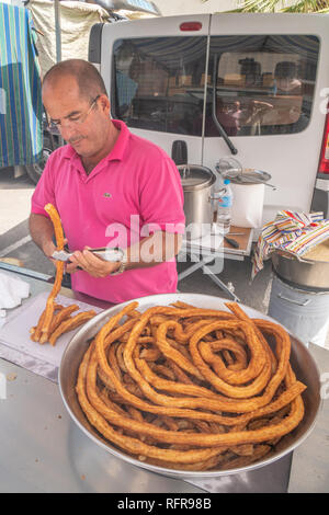 Padre e figlio preparazione churros in un mercato spagnolo Foto Stock