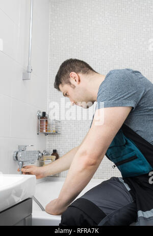 Installatore professionista assemblaggio flessibile per doccia in bagno. Foto Stock
