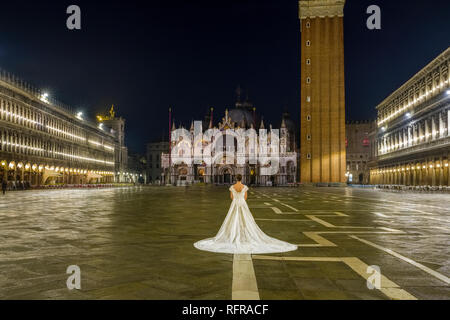 Una sposa in un abito da sposa è in piedi sulla Piazza San Marco, Piazza San Marco, di notte Foto Stock