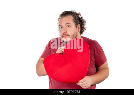 Un studio shot di un uomo grasso tenendo un rosso a forma di cuore isolato di cuscino Foto Stock