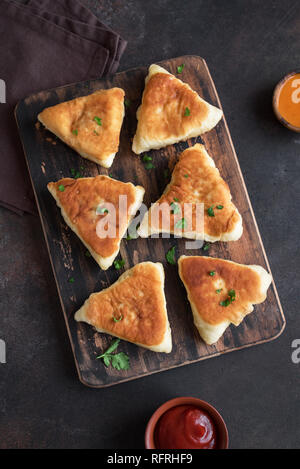 Fritte torte di verdure, samsa, samosas, echpochmak - Le carni tradizionali torte ripiene o torte vegetariane su sfondo rustico, copia dello spazio. Foto Stock