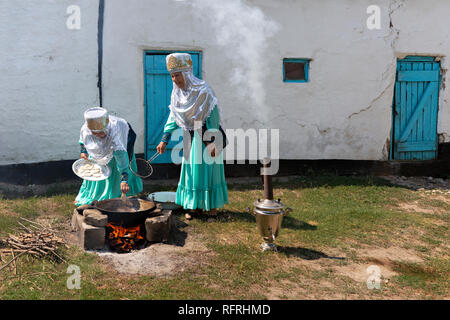 Il kazako donne in costumi tradizionali per la cottura tradizionale pane conosciuta come Baursak, in Shymkent in Kazakhstan. Foto Stock
