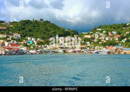 St George, Grenada, dei Caraibi - 23 Febbraio 2018: i suoi edifici colorati di Grenada illuminare il paesaggio nonostante il meteo nuvoloso. Foto Stock
