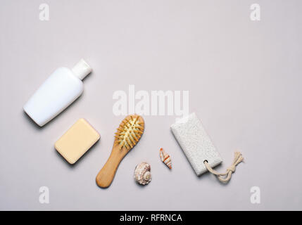 Gli articoli da bagno concetto, sapone, shampoo e gel doccia, spazzola per capelli, pietra pomice, vista dall'alto, laici piatta Foto Stock