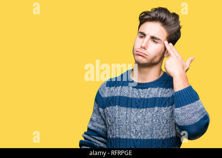 Giovane uomo bello su sfondo isolato sparare e uccidere se stessi puntando la mano e le dita alla testa, suicidio gesto. Foto Stock