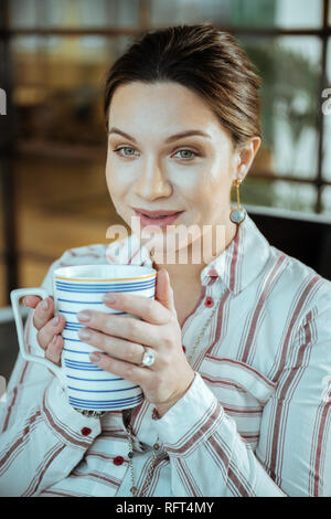 Close up della bella dai capelli scuri azienda donna grande tazza di tè Foto Stock