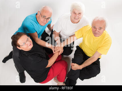 Gruppo di anziani felice facendo sport indossando variopinti t-shirts Foto Stock