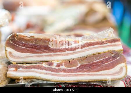 Due pezzi di carne di maiale affumicata. Deliziosa tutta artigianale affumicata pancetta lastra su un blocco di taglio. Pancetta di maiale fattoria fresco di maiale. Foto Stock