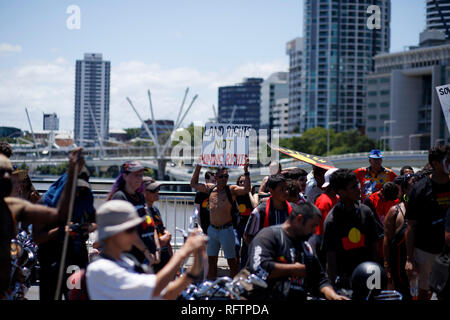 Un manifestante detiene un segno a dettare contro diritti minerari in Australia durante la protesta. Il 26 gennaio, molti australiani celebrare l'Australia Day, ma per molti indigeni popolo australiano, si tratta di un giorno è sinonimo di decenni di abusi sistematici e il genocidio. Diverse migliaia di manifestanti hanno preso le strade a Brisbane (noto come Meanjin dai popoli indigeni locali) al rally per i diritti di sovranità e la data delle modifiche. Foto Stock