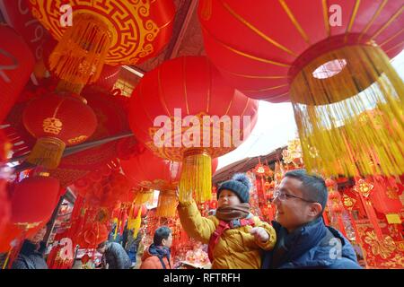 (190127) -- PECHINO, Gennaio 27, 2019 (Xinhua) -- persone selezionare Festival di Primavera di decorazioni in un mercato di Qingdao, Cina orientale della provincia di Shandong, Gennaio 26, 2019. Il Festival di Primavera, che cade il 5 febbraio di quest'anno, serve come un importante occasione per riunioni familiari e segna l inizio del nuovo anno lunare cinese. Si tratta di una tradizione cinese per acquistare merci che vanno dai prodotti alimentari agli elettrodomestici per celebrare il festival. I fornitori ed i fornitori di tutto il paese hanno preparato un sacco di prodotti per soddisfare le esigenze di shopping durante la vacanza spendendo spree. (Xinhua/Wang Haibin) Foto Stock