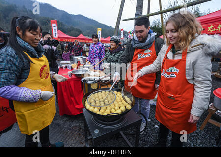 (190127) -- PECHINO, Gennaio 27, 2019 (Xinhua) -- i visitatori stranieri imparare a cucinare fried tofu ad una fiera locale di vendita specialità provenienti da zone montane in Hangzhou, est della Cina di Provincia dello Zhejiang, Gennaio 19, 2019. Il Festival di Primavera, che cade il 5 febbraio di quest'anno, serve come un importante occasione per riunioni familiari e segna l inizio del nuovo anno lunare cinese. Si tratta di una tradizione cinese per acquistare merci che vanno dai prodotti alimentari agli elettrodomestici per celebrare il festival. I fornitori ed i fornitori di tutto il paese hanno preparato un sacco di prodotti per soddisfare le esigenze di shopping durante la spesa per le vacanze Foto Stock