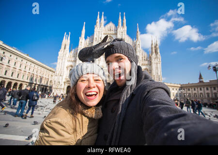 Viaggi, Italia e divertente giovane concetto - Happy turisti prendendo un autoritratto con piccioni nella parte anteriore del Duomo di Milano Foto Stock