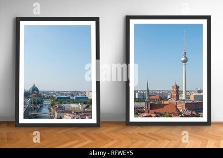 Due foto incorniciate di Berlin skyline sul pavimento in legno bianco sullo sfondo della parete Foto Stock