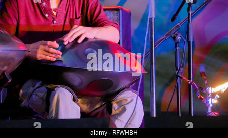 Uomo serbatoio di suonare il tamburo o appendere sul palco di etnia concerto all'aperto. Relax, folk, meditativa e tradizionale musica etnica concept Foto Stock