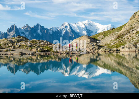 Gli escursionisti e la vetta del Mont Blanc si riflette in Lac Blanc sul Tour du Mont Blanc percorso di trekking, Haute Savoie, Auvergne-Rhone-Alpes, Francia Foto Stock