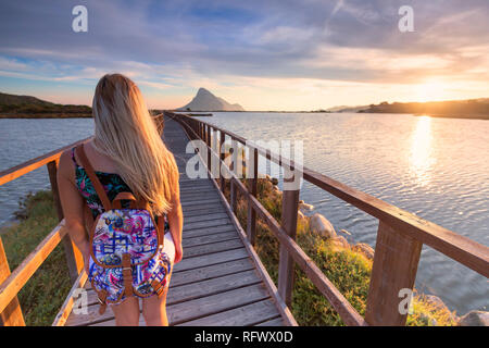 Una bambina guarda al sorgere del sole da un passaggio pedonale, Porto Taverna, Loiri Porto San Paolo, Olbia Tempio provincia, Sardegna, Italia, Mediterraneo, Europa Foto Stock